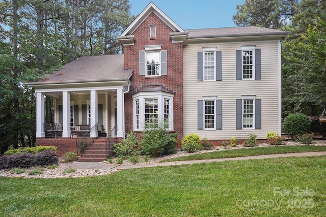 134 Lake Spring Loop, Mooresville, NC 28117 - view of front facade featuring a front yard, a porch, and brick siding