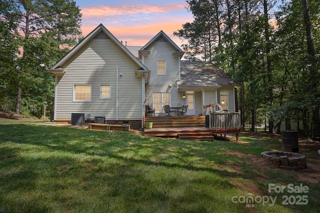134 Lake Spring Loop, Mooresville, NC 28117 - back of property at dusk with a fire pit, a lawn, a deck, and central AC