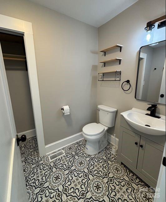 410 Gann St, Lowell, NC 28098 - bathroom featuring baseboards, toilet, vanity, and tile patterned floors