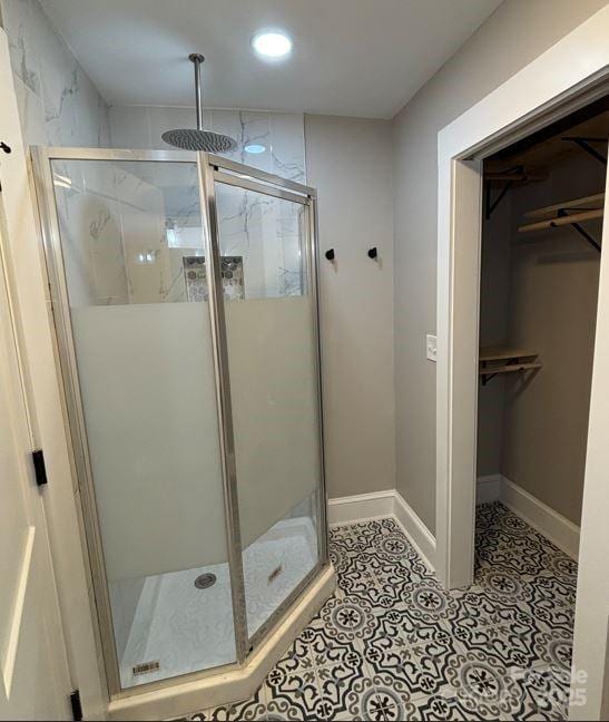 410 Gann St, Lowell, NC 28098 - bathroom with recessed lighting, a stall shower, a walk in closet, baseboards, and tile patterned flooring