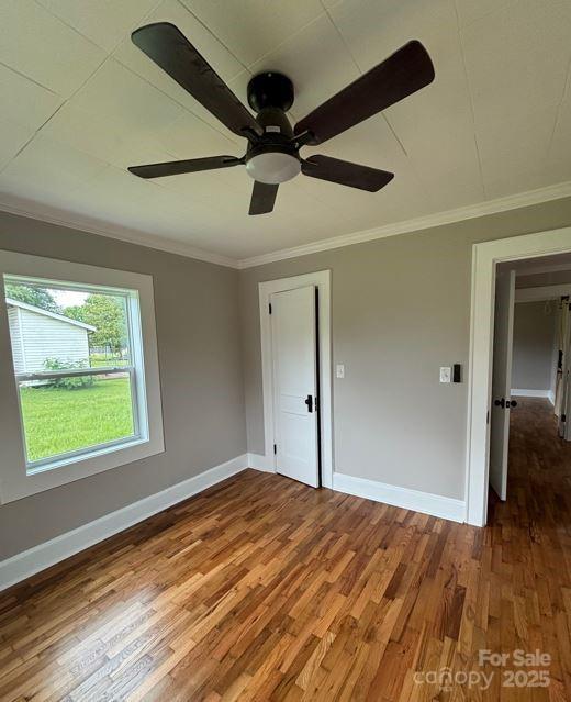 410 Gann St, Lowell, NC 28098 - spare room featuring ornamental molding, a ceiling fan, wood finished floors, and baseboards