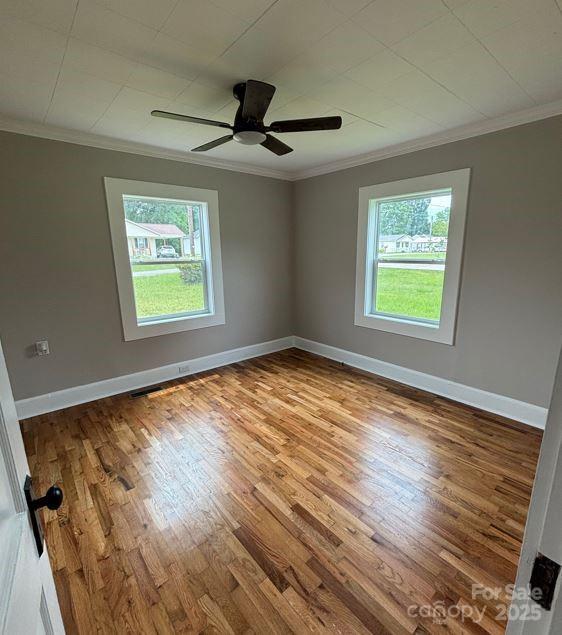 410 Gann St, Lowell, NC 28098 - unfurnished room with crown molding, wood finished floors, and a ceiling fan