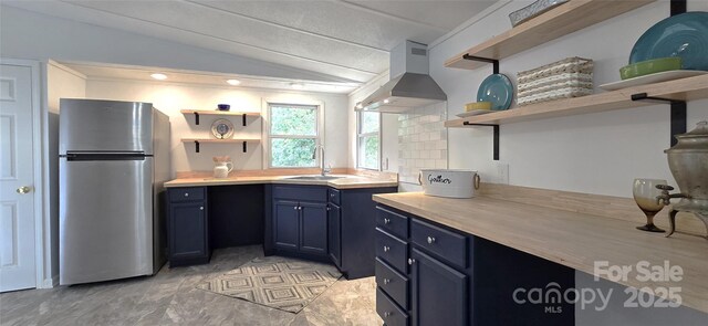 6140 Barclay Ln, Clover, SC 29710 - kitchen with open shelves, freestanding refrigerator, wall chimney exhaust hood, a sink, and lofted ceiling