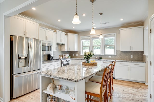 4511 Middlebury Ln, Fort Mill, SC 29715 - kitchen featuring appliances with stainless steel finishes, open shelves, white cabinets, ornamental molding, and a kitchen breakfast bar