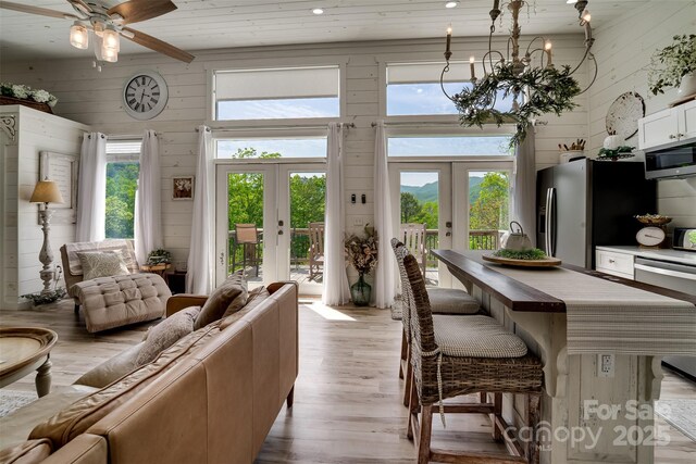 354 Ivy Ridge Cir, Sylva, NC 29779 - living room with french doors, healthy amount of natural light, light wood finished floors, wooden walls, and a towering ceiling