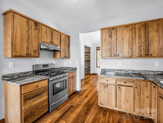 4830 Chesnee Rd, Rutherfordton, NC 28139 - kitchen with stainless steel gas range, under cabinet range hood, dark wood finished floors, dark stone countertops, and brown cabinets
