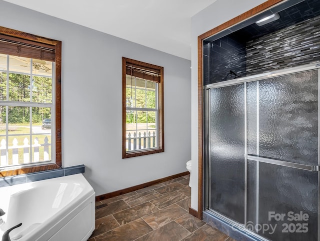 4830 Chesnee Rd, Rutherfordton, NC 28139 - bathroom featuring a stall shower, a garden tub, baseboards, and toilet