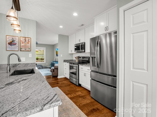 725 Center St, Asheville, NC 28803 - kitchen featuring stainless steel appliances, a sink, dark wood finished floors, light stone countertops, and recessed lighting