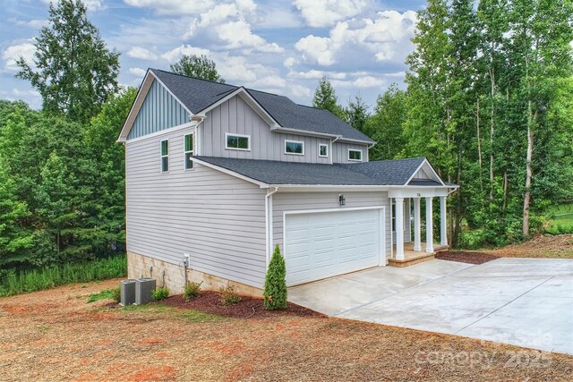 126 Meadow Glen Dr, Troutman, NC 28166 - view of side of property with board and batten siding, driveway, roof with shingles, a garage, and central air condition unit
