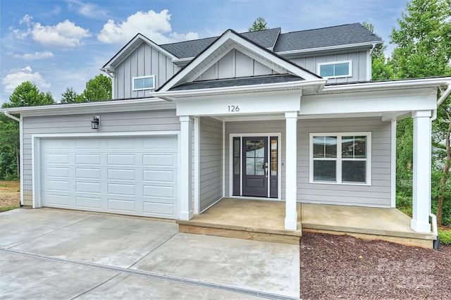 126 Meadow Glen Dr, Troutman, NC 28166 - view of front of house with board and batten siding, covered porch, driveway, and a garage