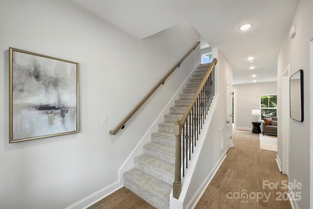 126 Meadow Glen Dr, Troutman, NC 28166 - stairs featuring wood finished floors, baseboards, and recessed lighting