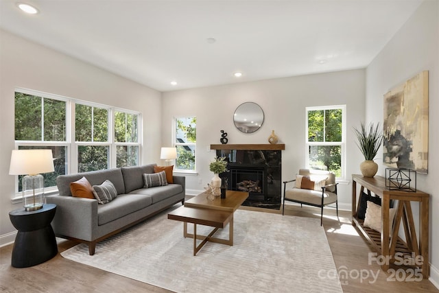 126 Meadow Glen Dr, Troutman, NC 28166 - living area featuring plenty of natural light, wood finished floors, recessed lighting, baseboards, and a tile fireplace