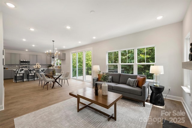 126 Meadow Glen Dr, Troutman, NC 28166 - living area featuring light wood-type flooring, recessed lighting, a chandelier, and baseboards