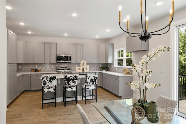 126 Meadow Glen Dr, Troutman, NC 28166 - kitchen with gray cabinetry, appliances with stainless steel finishes, tasteful backsplash, a breakfast bar, and recessed lighting