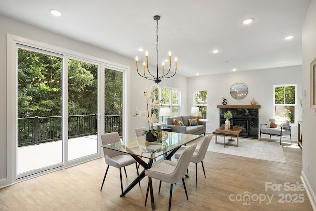 126 Meadow Glen Dr, Troutman, NC 28166 - dining space featuring healthy amount of natural light, recessed lighting, light wood-style floors, a high end fireplace, and a chandelier