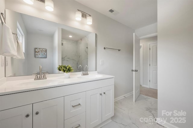 126 Meadow Glen Dr, Troutman, NC 28166 - bathroom featuring marble look tiles, a marble finish shower, double vanity, and baseboards