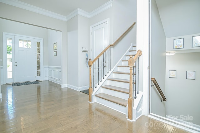 424 Cassia Ct, Fort Mill, SC 29708 - foyer featuring wood finished floors, stairs, crown molding, wainscoting, and a decorative wall