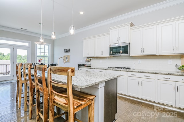 424 Cassia Ct, Fort Mill, SC 29708 - kitchen with stainless steel appliances, ornamental molding, a kitchen bar, backsplash, and decorative light fixtures