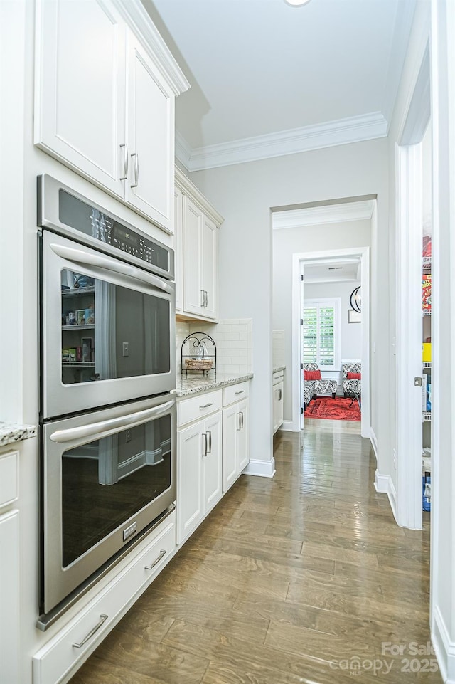 424 Cassia Ct, Fort Mill, SC 29708 - kitchen with stainless steel double oven, crown molding, baseboards, white cabinets, and wood finished floors