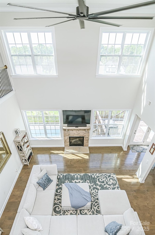 424 Cassia Ct, Fort Mill, SC 29708 - living area featuring a high ceiling, ceiling fan, a glass covered fireplace, wood finished floors, and baseboards