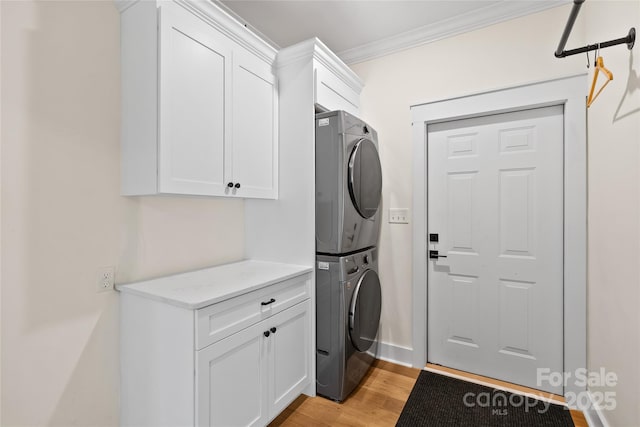 94 Jamestown Ln, Columbus, NC 28722 - washroom with stacked washer and clothes dryer, cabinet space, ornamental molding, light wood finished floors, and baseboards