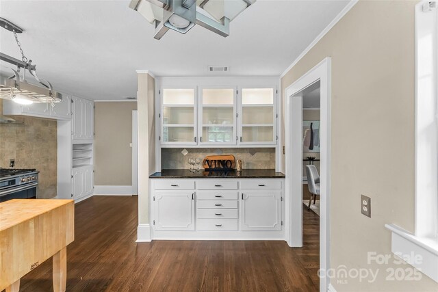 121 33rd Ave NE, Hickory, NC 28601 - kitchen with backsplash, ornamental molding, dark wood finished floors, glass insert cabinets, and dark countertops