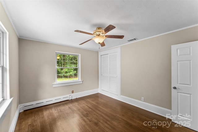 121 33rd Ave NE, Hickory, NC 28601 - unfurnished bedroom featuring a baseboard heating unit, baseboards, dark wood-type flooring, a closet, and crown molding