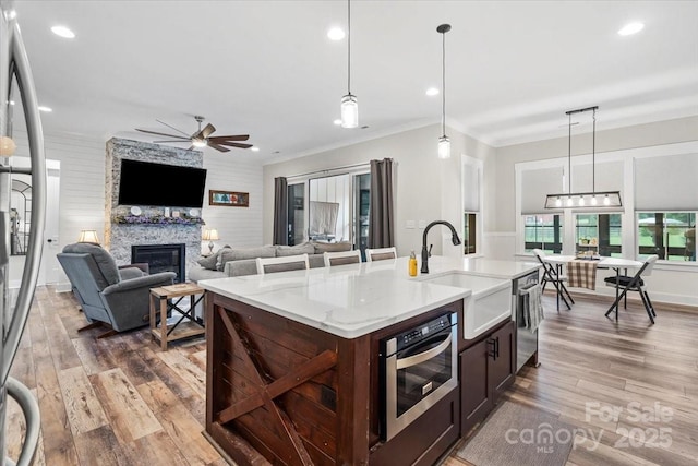 867 Bellegray Rd, Clover, SC 29710 - kitchen featuring stainless steel appliances, wood finished floors, ceiling fan, a fireplace, and open floor plan
