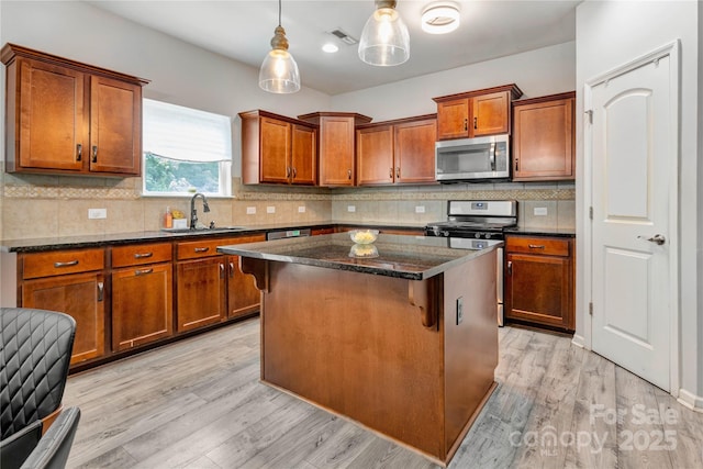1017 Quail Run Ct, Indian Land, SC 29707 - kitchen featuring appliances with stainless steel finishes, a sink, light wood-type flooring, and a center island