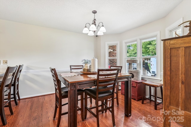 4527 Marshall Ct, Monroe, NC 28110 - dining room with wood finished floors, a chandelier, baseboards, and a textured ceiling