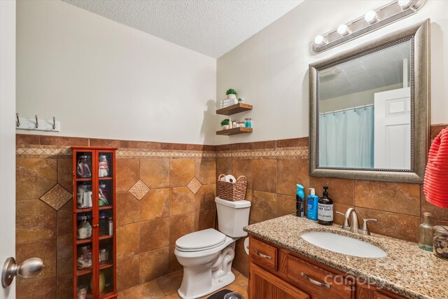 4527 Marshall Ct, Monroe, NC 28110 - full bath with vanity, toilet, a textured ceiling, tile walls, and wainscoting