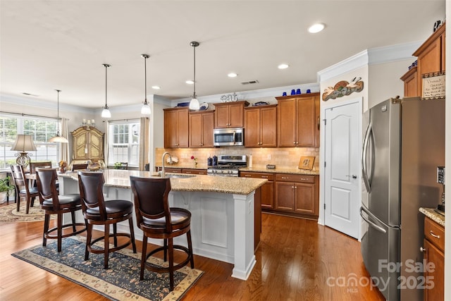 163 Carmen Way, Lancaster, SC 29720 - kitchen featuring appliances with stainless steel finishes, a sink, ornamental molding, brown cabinets, and light stone counters