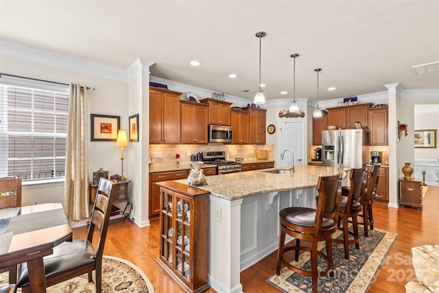 163 Carmen Way, Lancaster, SC 29720 - kitchen with stainless steel appliances, a sink, a kitchen island with sink, crown molding, and brown cabinetry