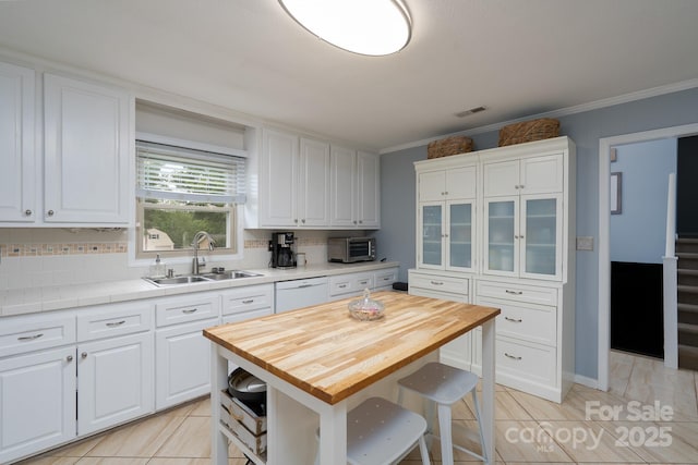318 Confederate Dr SW, Concord, NC 28027 - kitchen featuring a sink, white cabinetry, dishwasher, crown molding, and wood counters
