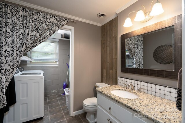 318 Confederate Dr SW, Concord, NC 28027 - bathroom with washer and dryer, toilet, tile walls, vanity, and tile patterned floors