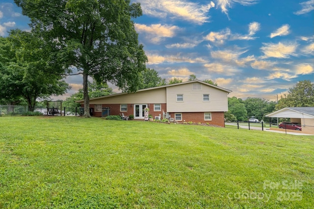 318 Confederate Dr SW, Concord, NC 28027 - back of house at dusk with french doors, brick siding, and a detached carport