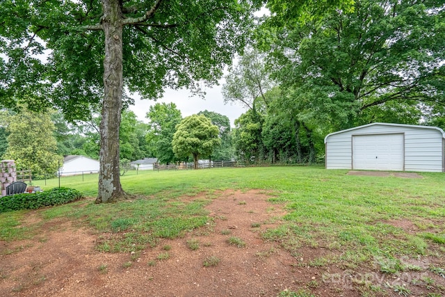 318 Confederate Dr SW, Concord, NC 28027 - view of yard featuring a garage, an outdoor structure, and view of wooded area
