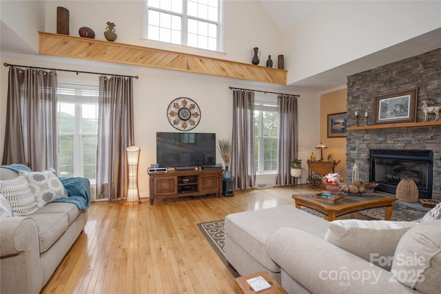 3690 Penland Rd, Spruce Pine, NC 28777 - living area featuring high vaulted ceiling, light wood-style floors, a stone fireplace, crown molding, and baseboards