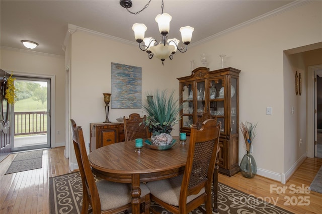 3690 Penland Rd, Spruce Pine, NC 28777 - dining area featuring a chandelier, light wood-type flooring, ornamental molding, and baseboards