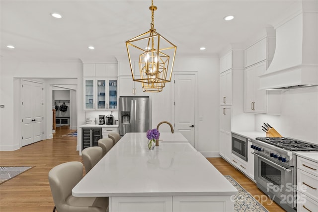 6013 Camile Ct, Charlotte, NC 28226 - kitchen with custom range hood, appliances with stainless steel finishes, a kitchen bar, a chandelier, and a sink