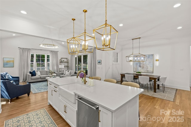 6013 Camile Ct, Charlotte, NC 28226 - kitchen with dishwasher, a sink, open floor plan, light wood-type flooring, and a chandelier