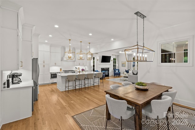 6013 Camile Ct, Charlotte, NC 28226 - dining area featuring a chandelier, a fireplace, light wood finished floors, and recessed lighting