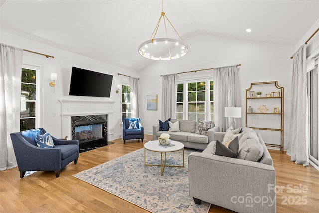 6013 Camile Ct, Charlotte, NC 28226 - living area featuring vaulted ceiling, a high end fireplace, light wood-type flooring, and a chandelier