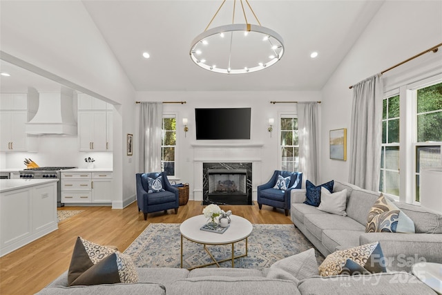 6013 Camile Ct, Charlotte, NC 28226 - living area with high vaulted ceiling, a high end fireplace, light wood-style floors, a chandelier, and recessed lighting