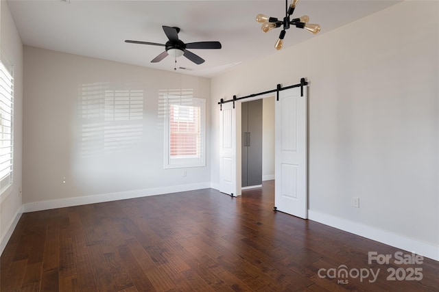 82 Wheeler Rd, Weaverville, NC 28787 - unfurnished bedroom featuring dark wood-style floors, a barn door, baseboards, and ceiling fan