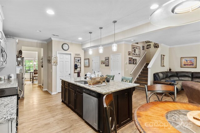 6010 Hawk View Rd, Waxhaw, NC 28173 - kitchen featuring stainless steel appliances, light wood-style floors, an island with sink, open floor plan, and light stone counters