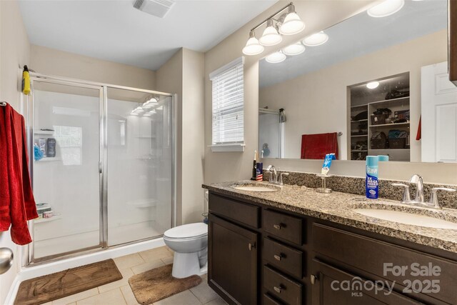 6010 Hawk View Rd, Waxhaw, NC 28173 - bathroom with a stall shower, double vanity, tile patterned floors, and a walk in closet