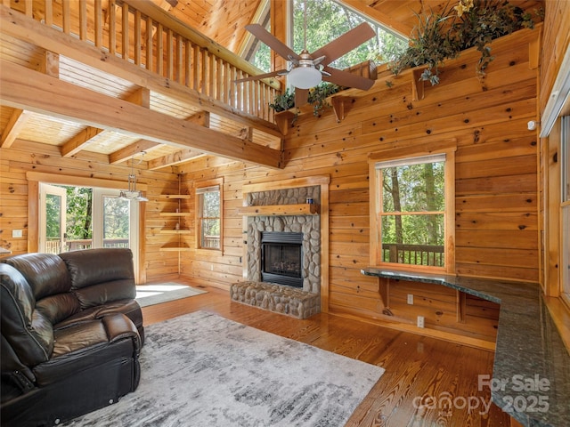 79 Acorn Ln, Rutherfordton, NC 28139 - living room featuring ceiling fan, wood-type flooring, plenty of natural light, a stone fireplace, and wooden walls