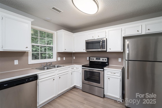 1520 28th St SW, Hickory, NC 28602 - kitchen with appliances with stainless steel finishes, a sink, white cabinets, a textured ceiling, and light countertops