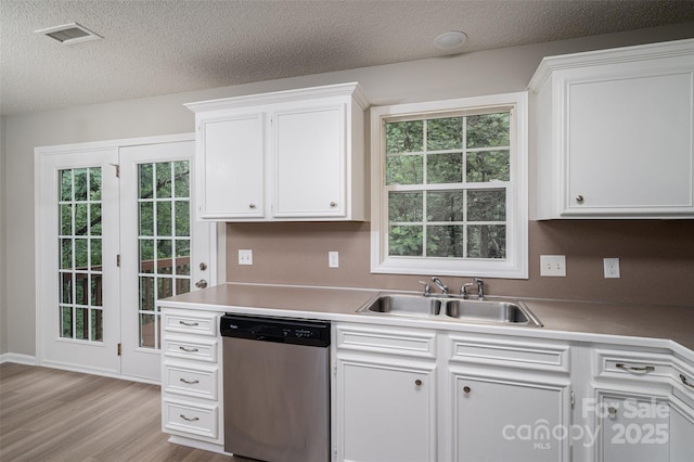 1520 28th St SW, Hickory, NC 28602 - kitchen featuring dishwasher, a sink, white cabinetry, light wood-style flooring, and a textured ceiling